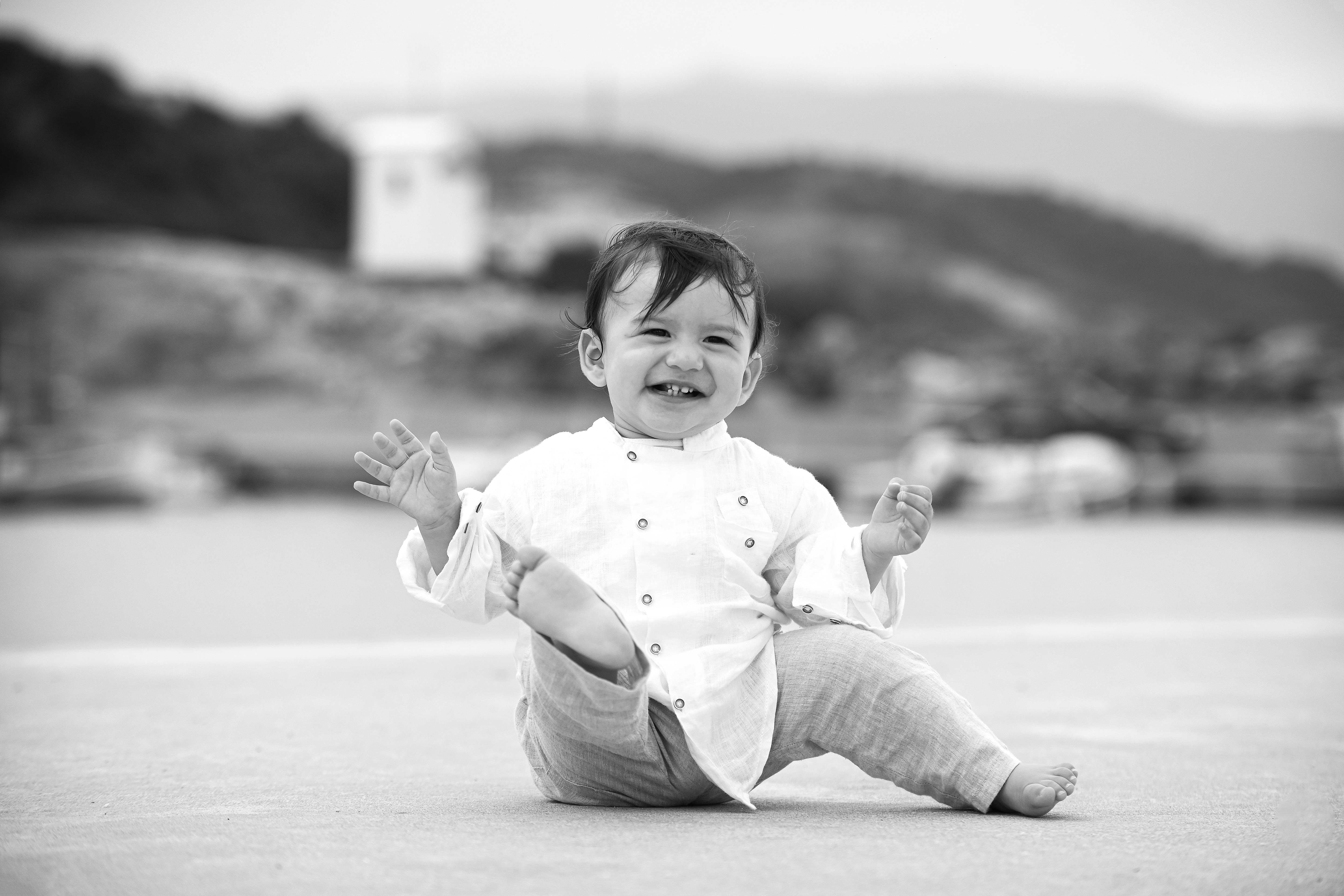 Ασπρόμαυρο χαρούμενο αγοράκι με λευκό πουκάμισο κοντά στη θάλασσα - Φωτογραφείο Κολοβός